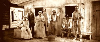 Movie still from “Harriet” (2019), directed by Kasi Lemmons – A group of people standing in front of a building; Wide shot, Low angle
