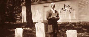 Movie still from “Harriet” (2019), directed by Kasi Lemmons – An old photo of a man standing next to a grave; Medium shot, Low angle