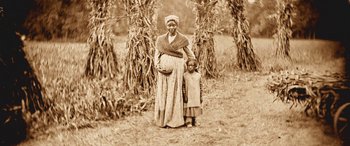 Movie still from “Harriet” (2019), directed by Kasi Lemmons – An old photograph of a woman and a child; Wide shot, High angle