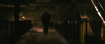 Movie still from “Harry Brown” (2009), directed by Daniel Barber – A man walking down a street at night; Wide shot, Low angle