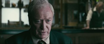Movie still from “Harry Brown” (2009), directed by Daniel Barber – An older man wearing a suit and tie; Close Up shot, Over the shoulder angle