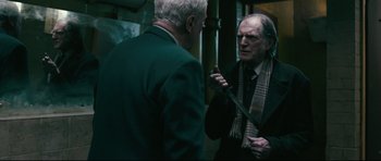 Movie still from “Harry Brown” (2009), directed by Daniel Barber – Two older men talking to each other in a dark room; Medium shot, Over the shoulder angle