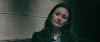 Movie still from “Harry Brown” (2009), directed by Daniel Barber – A woman with long hair wearing a suit and tie; Close Up shot, Over the shoulder angle