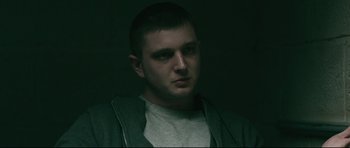 Movie still from “Harry Brown” (2009), directed by Daniel Barber – A man in a gray shirt is looking at the camera; Close Up shot, Low angle