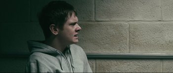 Movie still from “Harry Brown” (2009), directed by Daniel Barber – A young man is looking into the distance; Close Up shot, Over the shoulder angle