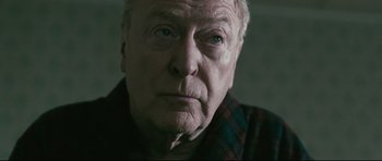 Movie still from “Harry Brown” (2009), directed by Daniel Barber – An older man with a beard and a plaid shirt; Close Up shot, Over the shoulder angle