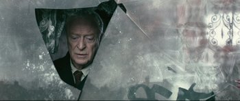 Movie still from “Harry Brown” (2009), directed by Daniel Barber – An older man in a business suit holding an open umbrella; Close Up shot, High angle