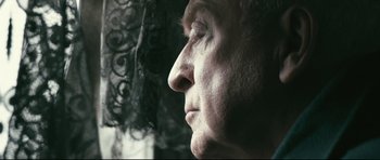 Movie still from “Harry Brown” (2009), directed by Daniel Barber – An older man looking out of a window; Extreme Close Up shot, Low angle