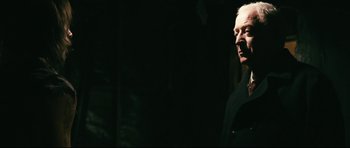 Movie still from “Harry Brown” (2009), directed by Daniel Barber – An older man standing in the dark with his hand up to his face; Close Up shot, Low angle