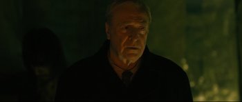 Movie still from “Harry Brown” (2009), directed by Daniel Barber – An older man wearing a black jacket and a neck tie; Close Up shot, Low angle