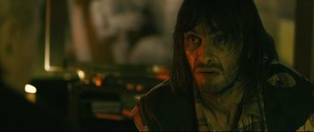 Movie still from “Harry Brown” (2009), directed by Daniel Barber – A person with long black hair; Close Up shot, Over the shoulder angle