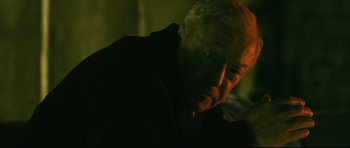 Movie still from “Harry Brown” (2009), directed by Daniel Barber – An older man is looking at the camera; Close Up shot, Over the shoulder angle