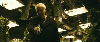 Movie still from “Harry Brown” (2009), directed by Daniel Barber – An older man holding a gun while standing in a room; Medium shot, Low angle
