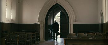 Movie still from “Harry Brown” (2009), directed by Daniel Barber – A person standing in front of an arched doorway; Wide shot, Low angle