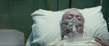Movie still from “Harry Brown” (2009), directed by Daniel Barber – An older man laying in a hospital bed; Close Up shot, Overhead angle