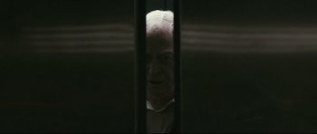 Movie still from “Harry Brown” (2009), directed by Daniel Barber – An older man looking through a window in a dark room; Close Up shot, Low angle