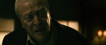 Movie still from “Harry Brown” (2009), directed by Daniel Barber – An old man with a beard is looking at the camera; Close Up shot, Over the shoulder angle