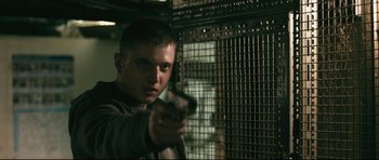 Movie still from “Harry Brown” (2009), directed by Daniel Barber – A man holding a gun in front of a window; Close Up shot, Over the shoulder angle