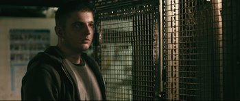 Movie still from “Harry Brown” (2009), directed by Daniel Barber – A man standing in front of a metal fence; Close Up shot, Low angle