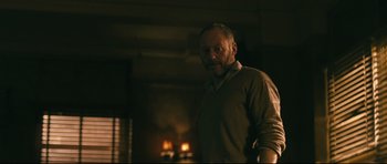Movie still from “Harry Brown” (2009), directed by Daniel Barber – A man standing in front of a fire place; Medium shot, Low angle