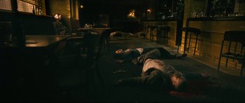 Movie still from “Harry Brown” (2009), directed by Daniel Barber – Two men laying on the ground in a dark room; Wide shot, High angle