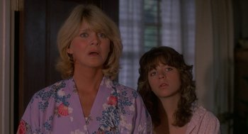 Movie still from “Harry and the Hendersons” (1987), directed by William Dear – Two women standing next to each other in front of a window; Close Up shot, Low angle