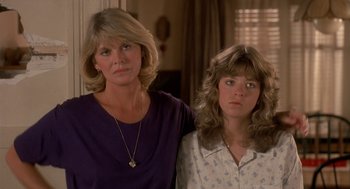 Movie still from “Harry and the Hendersons” (1987), directed by William Dear – A woman standing next to another woman in a room; Close Up shot, Low angle