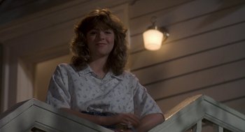 Movie still from “Harry and the Hendersons” (1987), directed by William Dear – A woman standing on top of a metal railing; Medium shot, Low angle