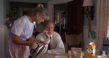 Movie still from “Harry and the Hendersons” (1987), directed by William Dear – A man and a woman at a table with a coffee pot; Medium shot, Over the shoulder angle