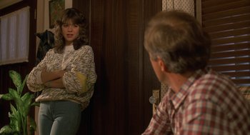 Movie still from “Harry and the Hendersons” (1987), directed by William Dear – A man and a woman are looking at each other in the mirror; Medium shot, Over the shoulder angle