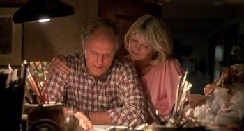 Movie still from “Harry and the Hendersons” (1987), directed by William Dear – An older man and a younger woman looking at papers; Close Up shot, Low angle