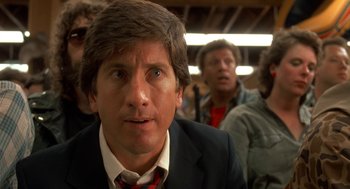 Movie still from “Harry and the Hendersons” (1987), directed by William Dear – A person wearing a suit and tie; Close Up shot, Low angle