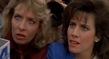 Movie still from “Harry and the Hendersons” (1987), directed by William Dear – Two women looking at the camera while one of the women is wearing a red jacket; Close Up shot, High angle