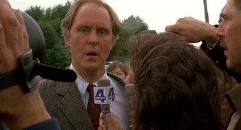 Movie still from “Harry and the Hendersons” (1987), directed by William Dear – A man is being interviewed by a reporter; Close Up shot, Over the shoulder angle