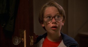 Movie still from “Harry and the Hendersons” (1987), directed by William Dear – A young boy wearing glasses looking at the camera; Close Up shot, Low angle