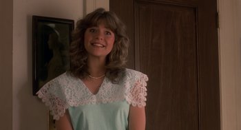 Movie still from “Harry and the Hendersons” (1987), directed by William Dear – A woman in a blue dress with a white lace top; Close Up shot, Over the shoulder angle