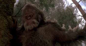 Movie still from “Harry and the Hendersons” (1987), directed by William Dear – An image of an animal that is sitting on a tree; Close Up shot, Low angle