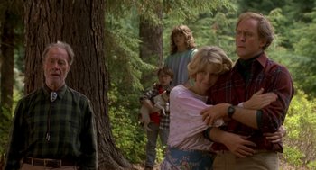 Movie still from “Harry and the Hendersons” (1987), directed by William Dear – A group of people standing in front of a tree in the woods; Medium shot, Over the shoulder angle