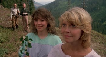 Two women standing on top of a hill