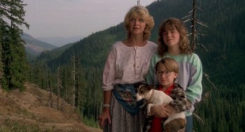 Movie still from “Harry and the Hendersons” (1987), directed by William Dear – A woman and two children standing next to each other; Wide shot, Low angle