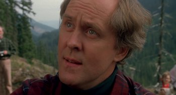 Movie still from “Harry and the Hendersons” (1987), directed by William Dear – A man with a beard looking into the distance; Close Up shot, Over the shoulder angle