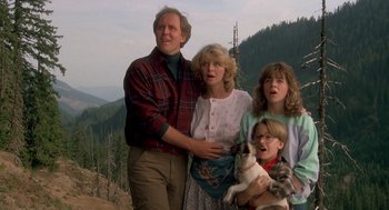 Movie still from “Harry and the Hendersons” (1987), directed by William Dear – A man , woman , and two children pose for a picture; Medium shot, Low angle