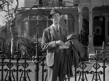 Movie still from “Harvey” (1950), directed by Henry Koster – A man standing in front of an iron fence; Medium shot, Low angle
