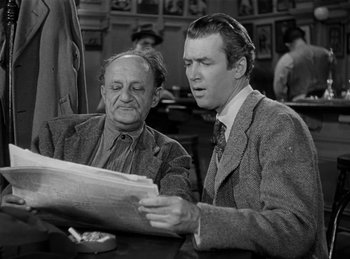 Movie still from “Harvey” (1950), directed by Henry Koster – Two men are sitting at a table and one is reading a newspaper; Medium shot, Over the shoulder angle