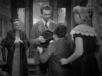 Movie still from “Harvey” (1950), directed by Henry Koster – An old photo of a group of people standing around; Medium shot, Over the shoulder angle