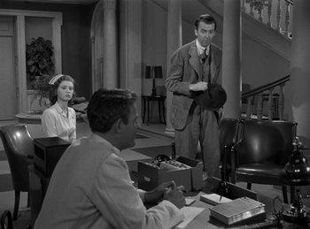 Movie still from “Harvey” (1950), directed by Henry Koster – A black and white photo of a man and a woman in a room; Medium shot, Over the shoulder angle