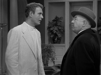 Movie still from “Harvey” (1950), directed by Henry Koster – A man in a suit and a man in a hat talking to each other; Medium shot, Over the shoulder angle