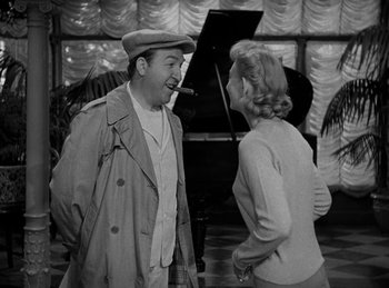 Movie still from “Harvey” (1950), directed by Henry Koster – An old photo of a man and a woman talking to each other in front of a grand piano; Medium shot, Over the shoulder angle