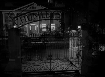 Movie still from “Harvey” (1950), directed by Henry Koster – A black - and - white photo of the front gate of a building; Wide shot, High angle