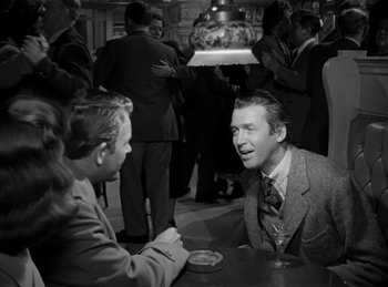 Movie still from “Harvey” (1950), directed by Henry Koster – A man and a woman are sitting at a table talking; Medium shot, Over the shoulder angle